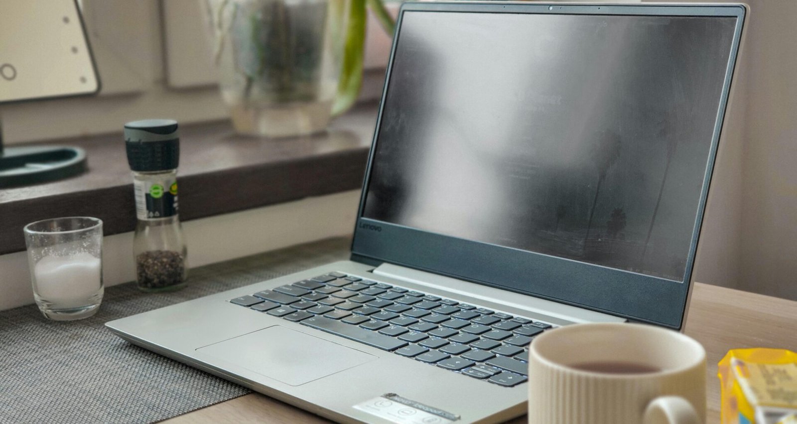 Ein Laptop steht auf einem Holzschreibtisch und bildet eine schlichte, professionelle Arbeitsumgebung für Digitalthemen ab.