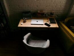 Ein Laptop-Computer steht auf einem hölzernen Schreibtisch, passend zum Thema moderne Arbeitsplätze und Homeoffice.