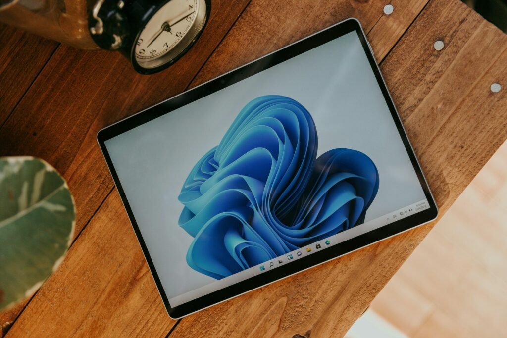 Ein Laptop-Computer steht auf einem hölzernen Schreibtisch in einem modernen Arbeitsumfeld