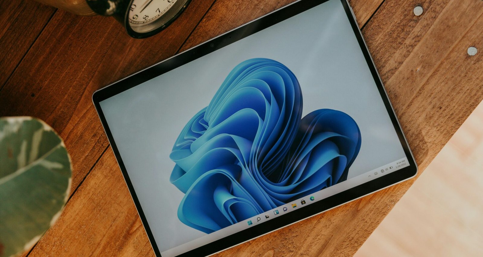 Ein Laptop-Computer steht auf einem hölzernen Schreibtisch in einem modernen Arbeitsumfeld