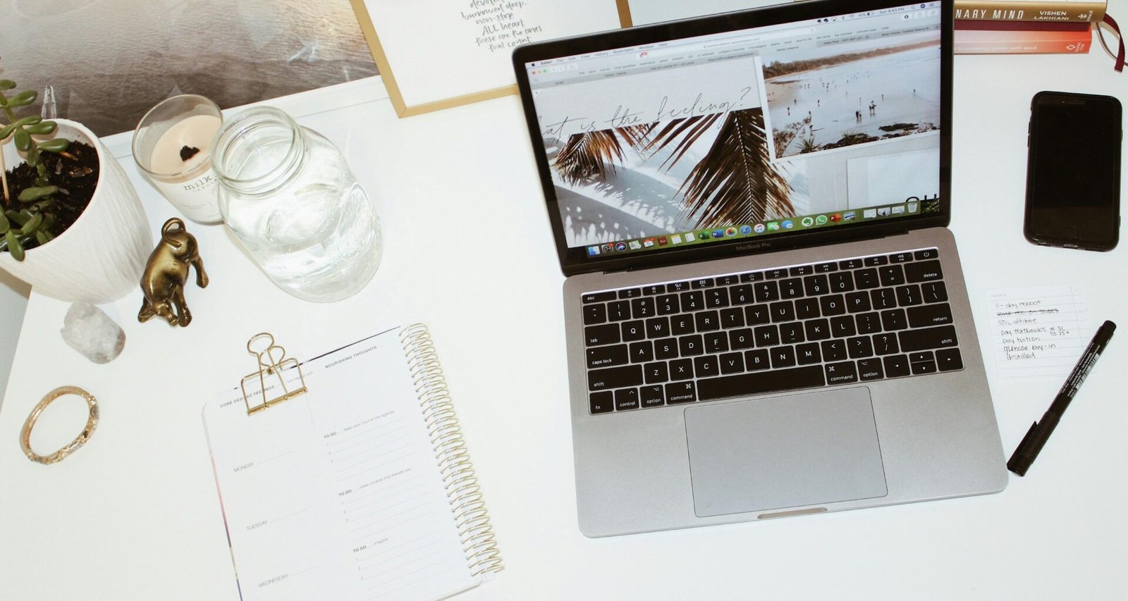 Ein moderner Laptop steht geöffnet auf einem weißen Schreibtisch in einem hellen Arbeitsumfeld mit minimalistischem Design.