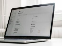 Ein Laptop steht auf einem weißen Tisch und ist bereit für den Einsatz im Homeoffice oder Büro.