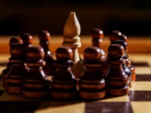 Ein Schachläufer befindet sich auf einem Schachbrett und ist von mehreren Bauern umgeben, fotografiert aus der Nähe.