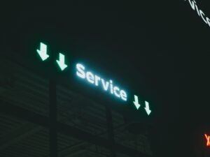 Leuchtendes Schild mit der Aufschrift 'service i x' vor dunklem Hintergrund, Symbol für digitale Services und Innovation