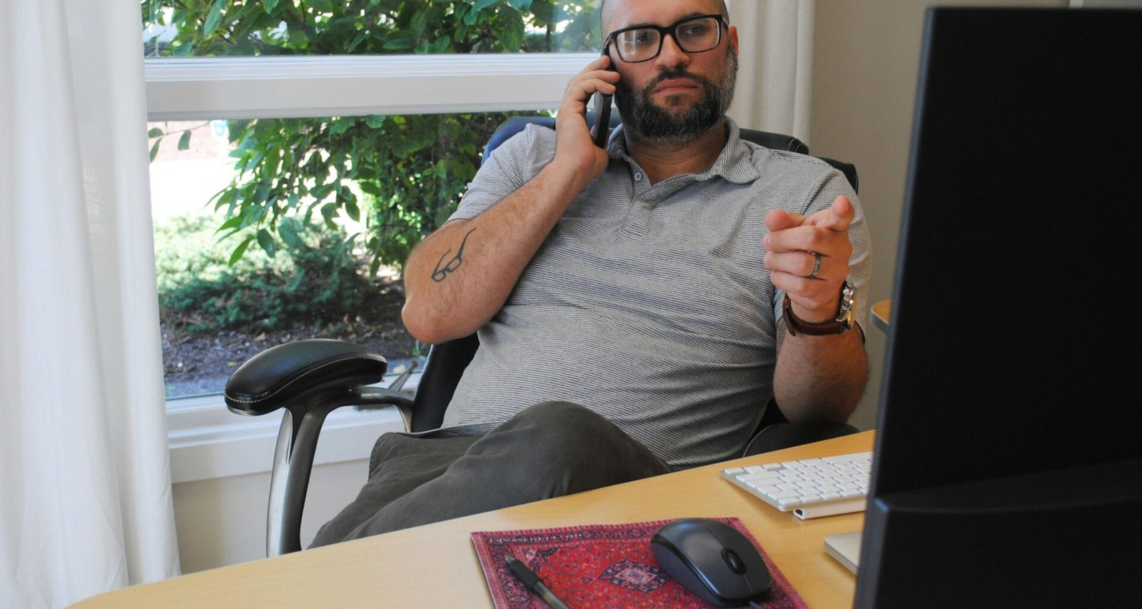 Ein Mann betrachtet sein Smartphone und interagiert mit dem Display während er steht