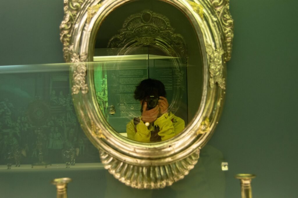 Erwachsener Mann nimmt mit seinem Smartphone ein Foto von sich selbst im Spiegel auf, klassisches digitales Selbstporträt.