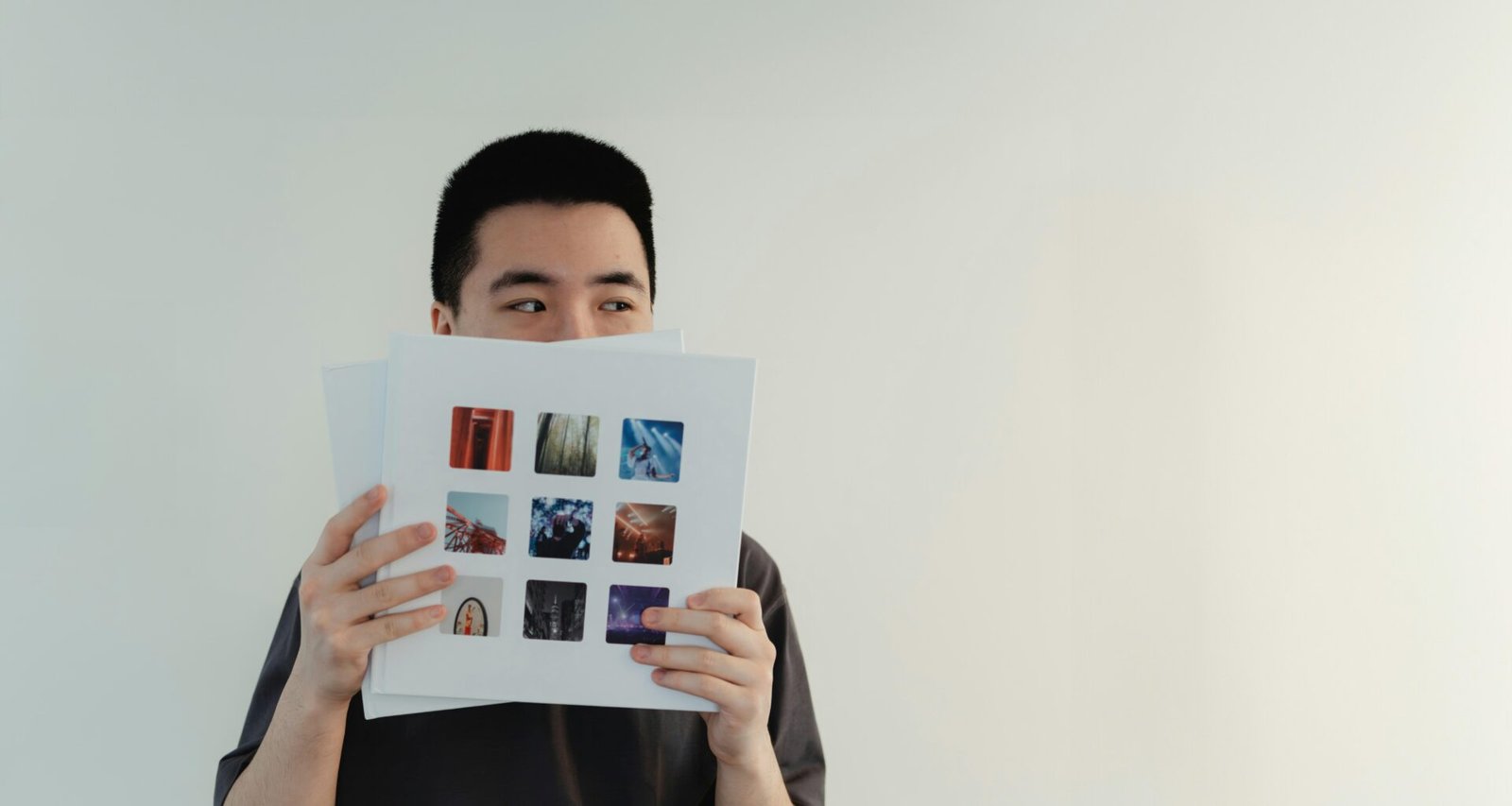 Ein Mann sitzt und hält ein Buch vor sein Gesicht, sodass nur seine Hände und das Buch sichtbar sind