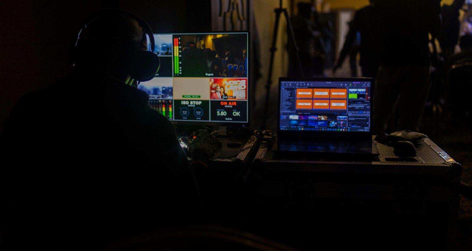 Ein Mann sitzt vor einem aufgeklappten Laptop am Schreibtisch und arbeitet, Fokus auf Technik und Bildschirm.