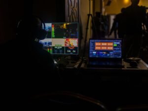 Ein Mann sitzt vor einem aufgeklappten Laptop am Schreibtisch und arbeitet, Fokus auf Technik und Bildschirm.