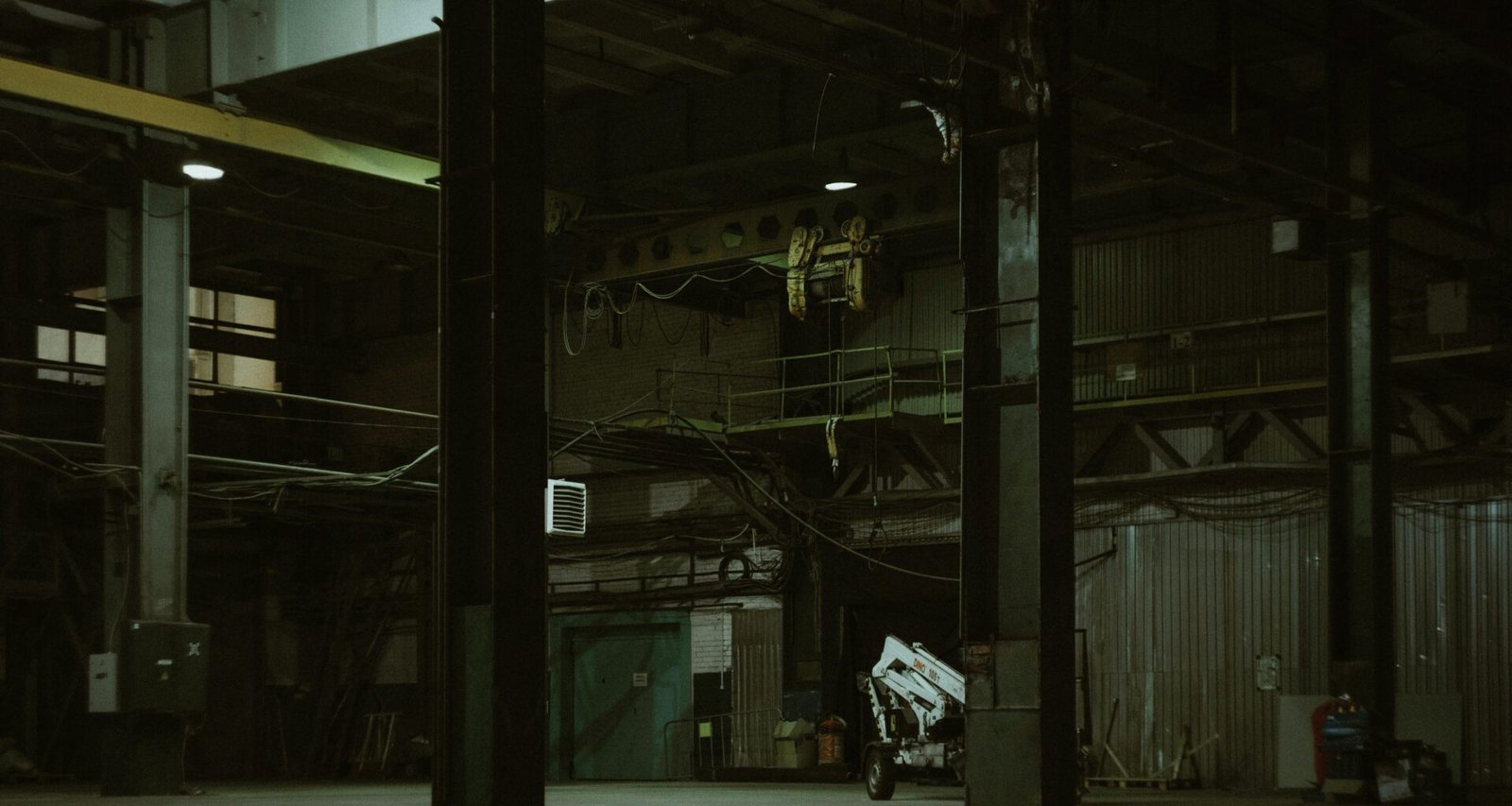 Ein Mann fährt auf einem Motorrad eine Straße entlang, flankiert von hohen Gebäuden und moderner Architektur.