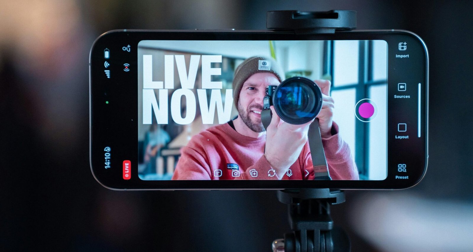 Ein Mann nimmt sich mit einem Smartphone auf, das auf einem Stativ befestigt ist, ideal für Videoproduktion oder Vlogging.