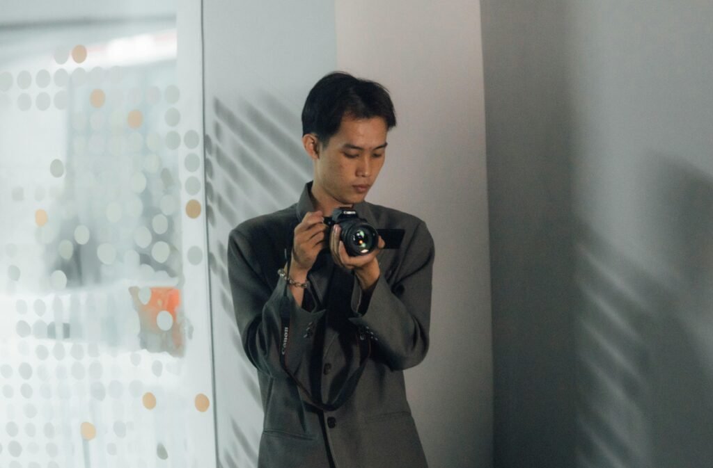 Ein Mann inspiziert eine Digitalkamera aus nächster Nähe, konzentriert auf technische Details und Bedienung.