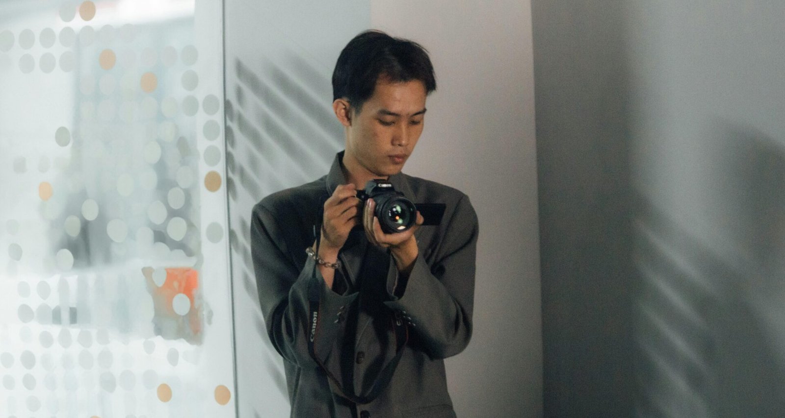 Ein Mann inspiziert eine Digitalkamera aus nächster Nähe, konzentriert auf technische Details und Bedienung.