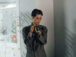 Ein Mann inspiziert eine Digitalkamera aus nächster Nähe, konzentriert auf technische Details und Bedienung.