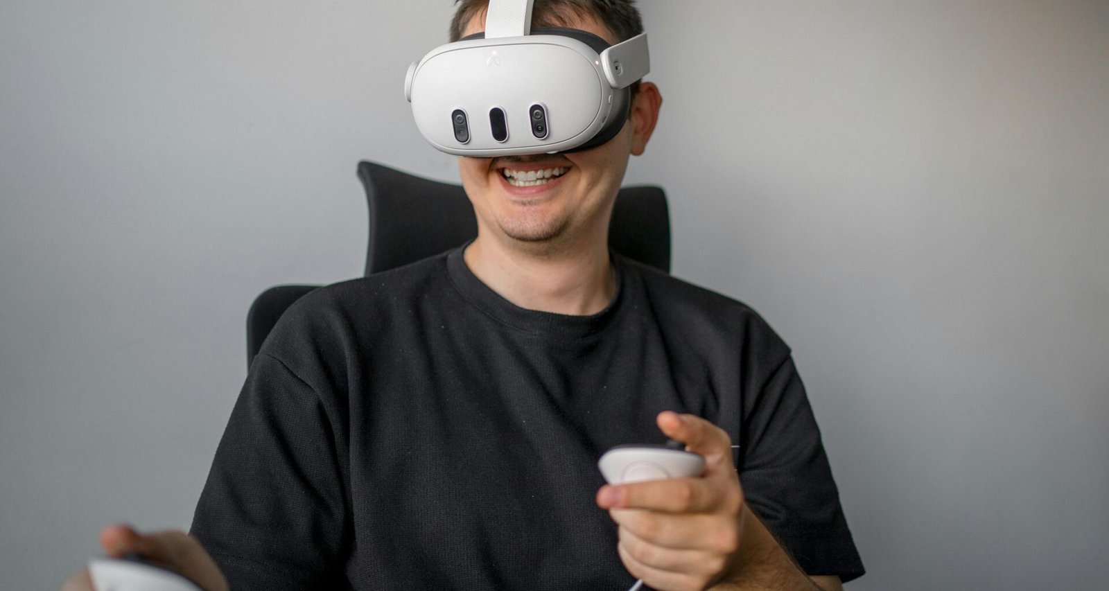 Ein Mann sitzt in einem Stuhl und hält eine Fernbedienung in der Hand, bereit zur Steuerung von Mediengeräten.