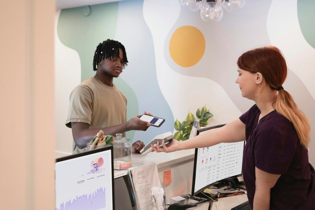 Ein Mann und eine Frau stehen gemeinsam vor einem großen Computerbildschirm in einem modernen Büro