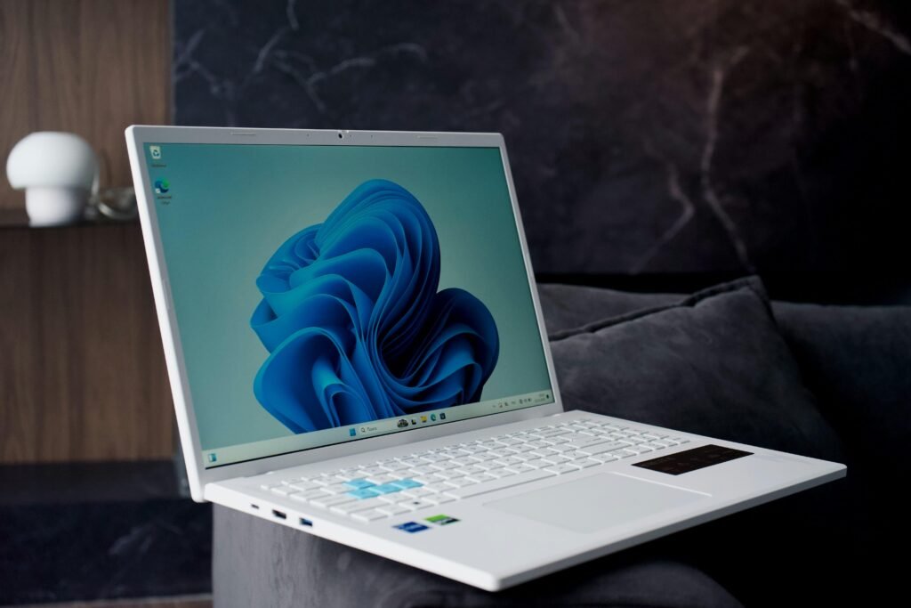 Weißes Laptop mit blauem abstraktem Wallpaper, perfekt geeignet für Technologiethemen und digitale Marketinginhalte.