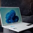 Weißes Laptop mit blauem abstraktem Wallpaper, perfekt geeignet für Technologiethemen und digitale Marketinginhalte.