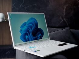 Weißes Laptop mit blauem abstraktem Wallpaper, perfekt geeignet für Technologiethemen und digitale Marketinginhalte.