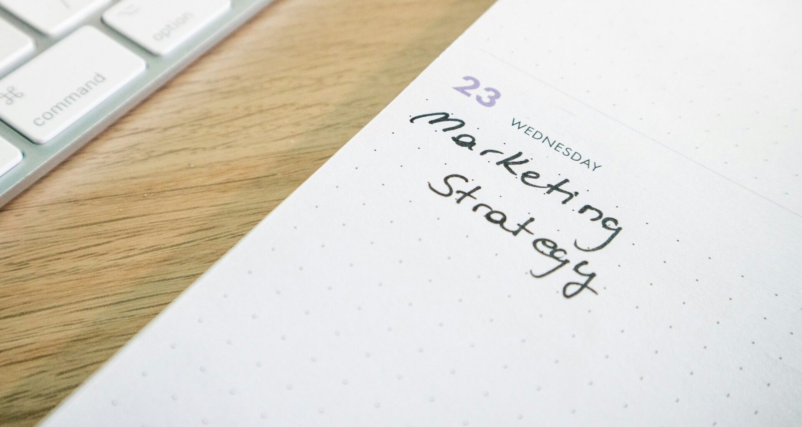 Notizblock mit handschriftlich vermerkter Marketingstrategie auf einem Schreibtisch, fokussiert auf effiziente Planung