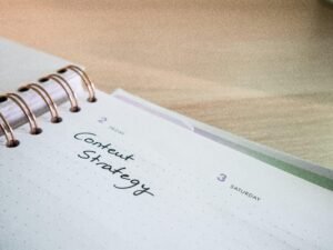 Ein Notizblock mit einem Spiralheft obenauf liegt auf einem Tisch – ideal für Notizen und Planung im Büroalltag.