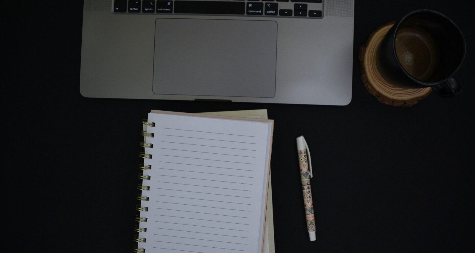 Notizbuch und Stift liegen auf einem hellen Schreibtisch und bieten Platz für Notizen oder Planungen.