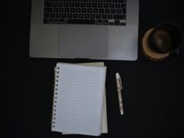 Notizbuch und Stift liegen auf einem ordentlichen Schreibtisch. Ideale Umgebung für Planungen und Notizen zu digitalen Themen.