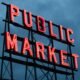 Leuchtendes Public Market Schild in der Nacht, ideal für Beiträge über urbane Märkte und Stadtentwicklung