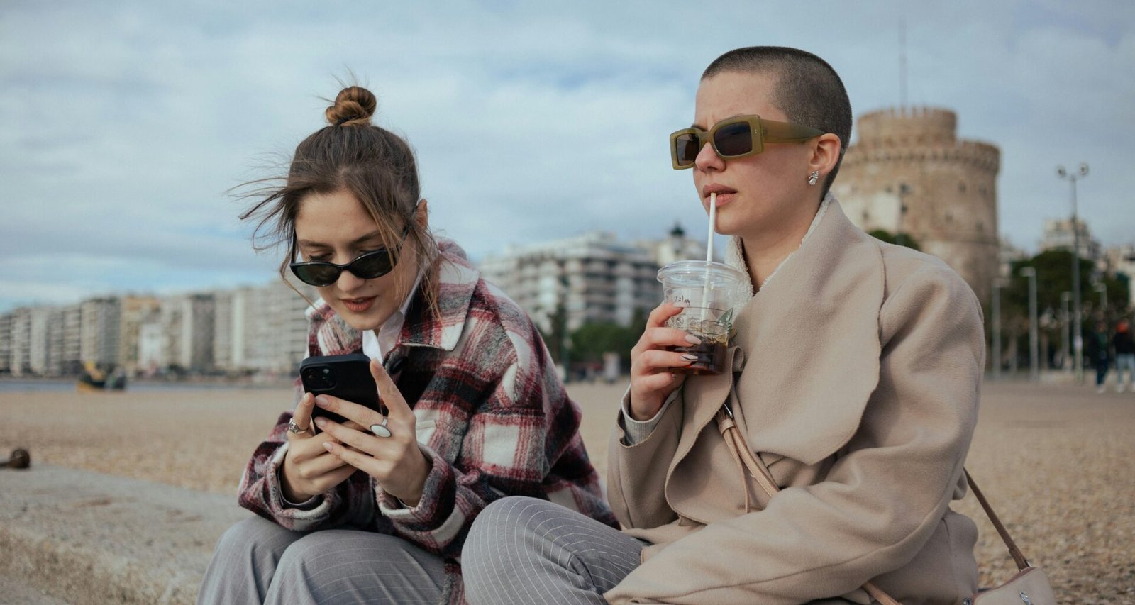 Zwei Frauen sitzen nebeneinander auf einer Bank und führen ein Gespräch, Aufnahme von Aleksandar Andreev.