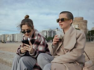 Zwei Frauen sitzen nebeneinander auf einer Bank und führen ein Gespräch, Aufnahme von Aleksandar Andreev.