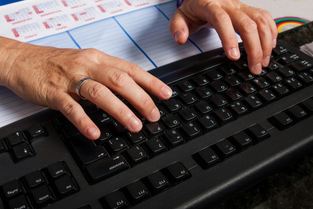 Zwei Hände auf einer Computertastatur beim Tippen, fotografiert für ein Thema über digitale Arbeit oder Online-Marketing