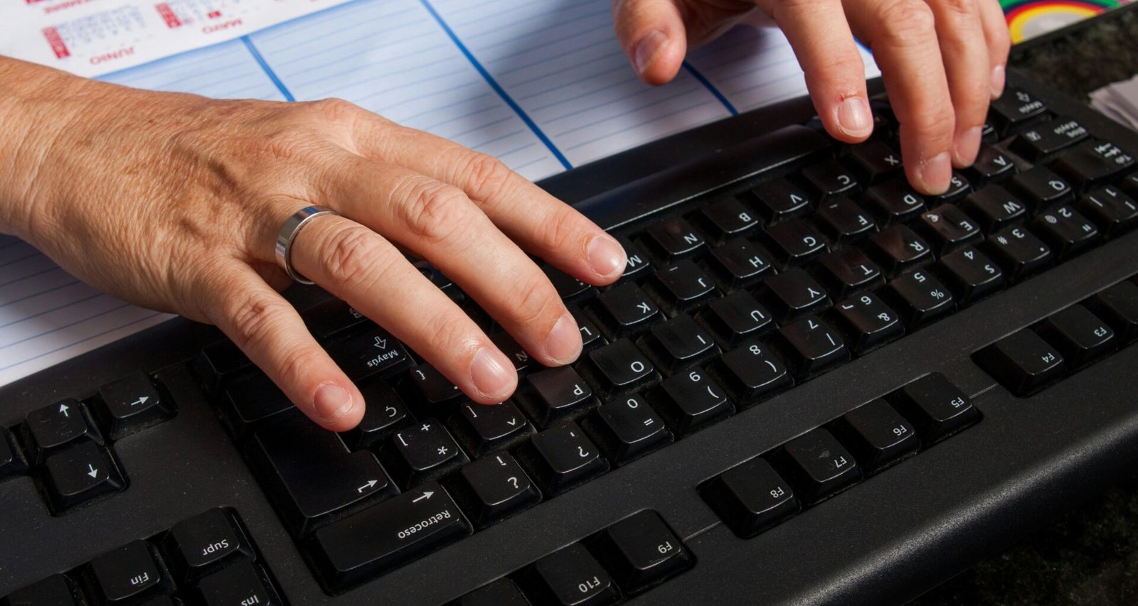 Zwei Hände tippen auf einer Computertastatur und stehen für digitale Arbeit am modernen Arbeitsplatz.