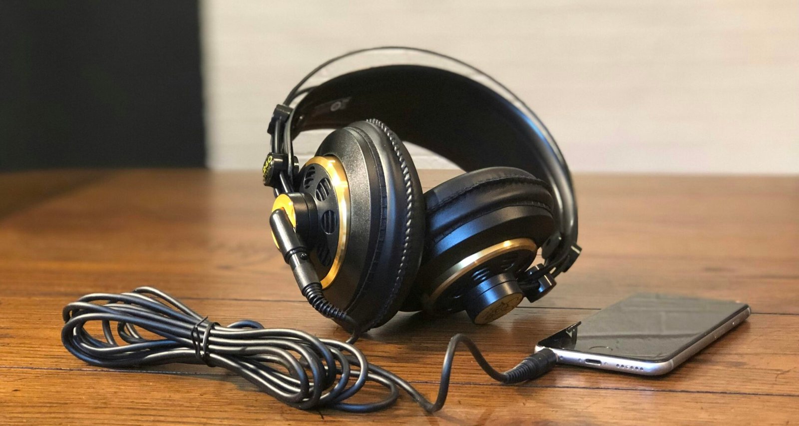 Ein Paar Kopfhörer liegt auf einem hölzernen Tisch – perfekte Darstellung moderner Audiotechnik im Alltag.
