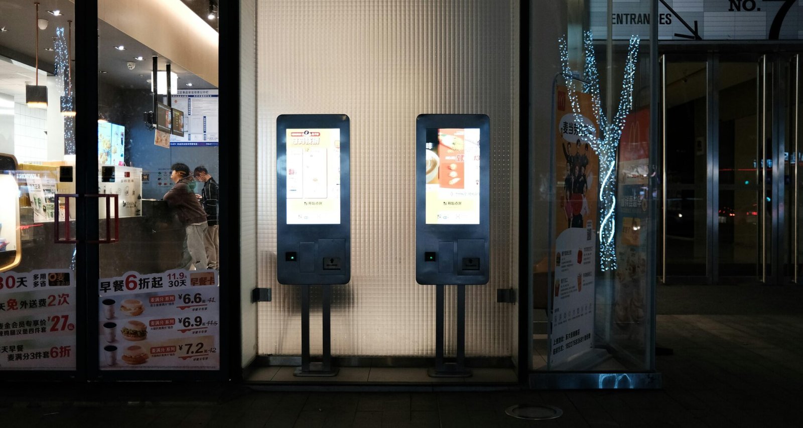 Zwei Maschinen stehen nebeneinander im Innenbereich eines Gebäudes. Moderne Technik, industrielle Umgebung, passend für Technologieartikel.