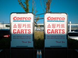 Mehrere Verkehrsschilder vor geparkten Autos in einer urbanen Umgebung, deutliche Sicht auf Fahrzeuge und Schilder.