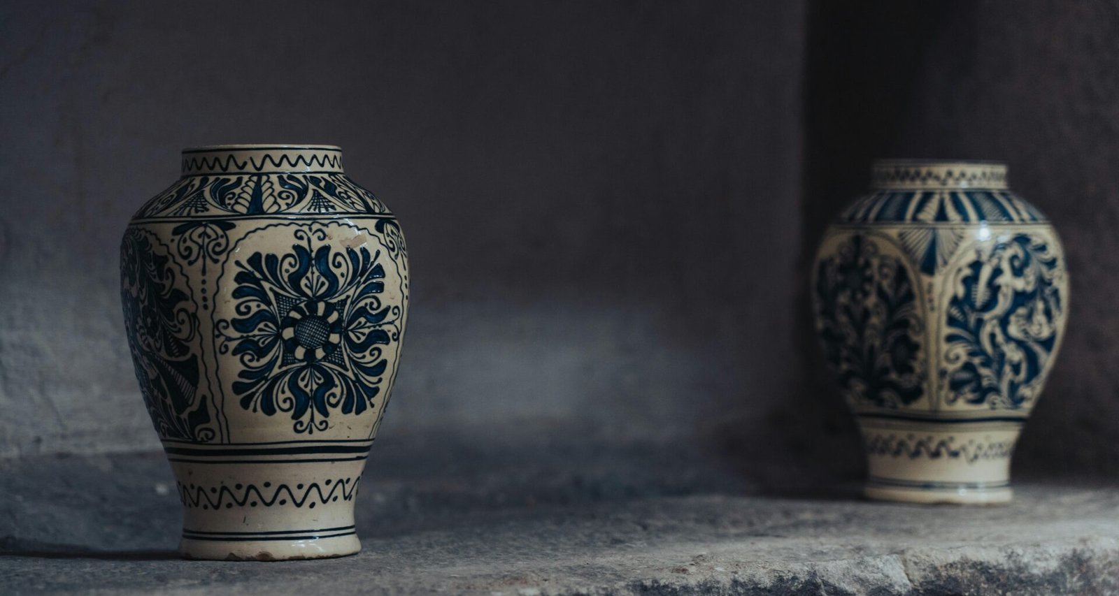 Zwei Vasen, arrangiert auf einer Steinmauer, eignen sich als stilvolle Dekoration für verschiedene Raumsituationen.