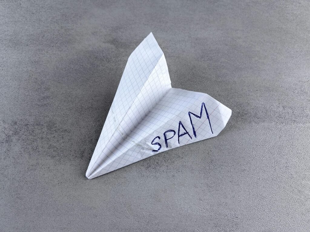 Ein Papierflieger mit dem Wort Spam darauf, symbolisiert unerwünschte E-Mail-Nachrichten im digitalen Marketing.