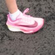 Ein einzelner pinker Sportschuh steht auf einem dunklen Untergrund und hebt sich durch sein modernes Design hervor.