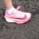 Ein einzelner pinker Sportschuh steht auf einem dunklen Untergrund und hebt sich durch sein modernes Design hervor.