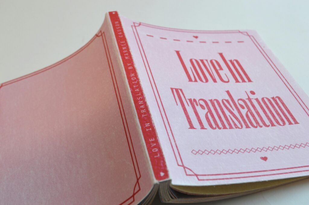 Ein pinkes Buch mit rotem Umschlag liegt auf einem weißen Hintergrund und sorgt für klaren, modernen Kontrast.