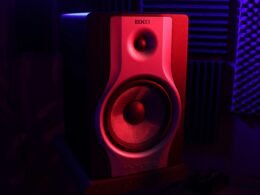 Roter und schwarzer Lautsprecher auf einem Schreibtisch, modernes Audio-Equipment für das Büro oder Homeoffice