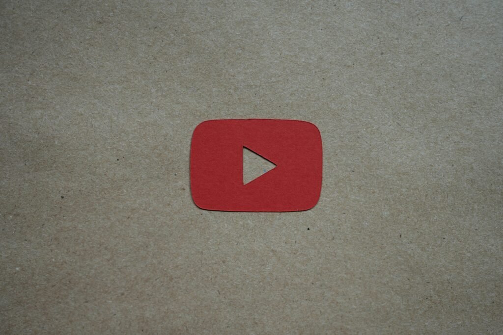 Ein roter Play-Button liegt auf einem weißen Blatt Papier und steht symbolisch für digitale Videoinhalte und Online-Marketing.