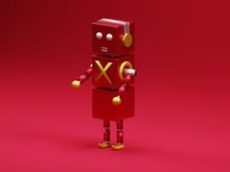 Ein roter Roboter steht frontal auf einem einfarbig pinken Hintergrund. Klare Linien und leuchtende Farben dominieren das Bild.