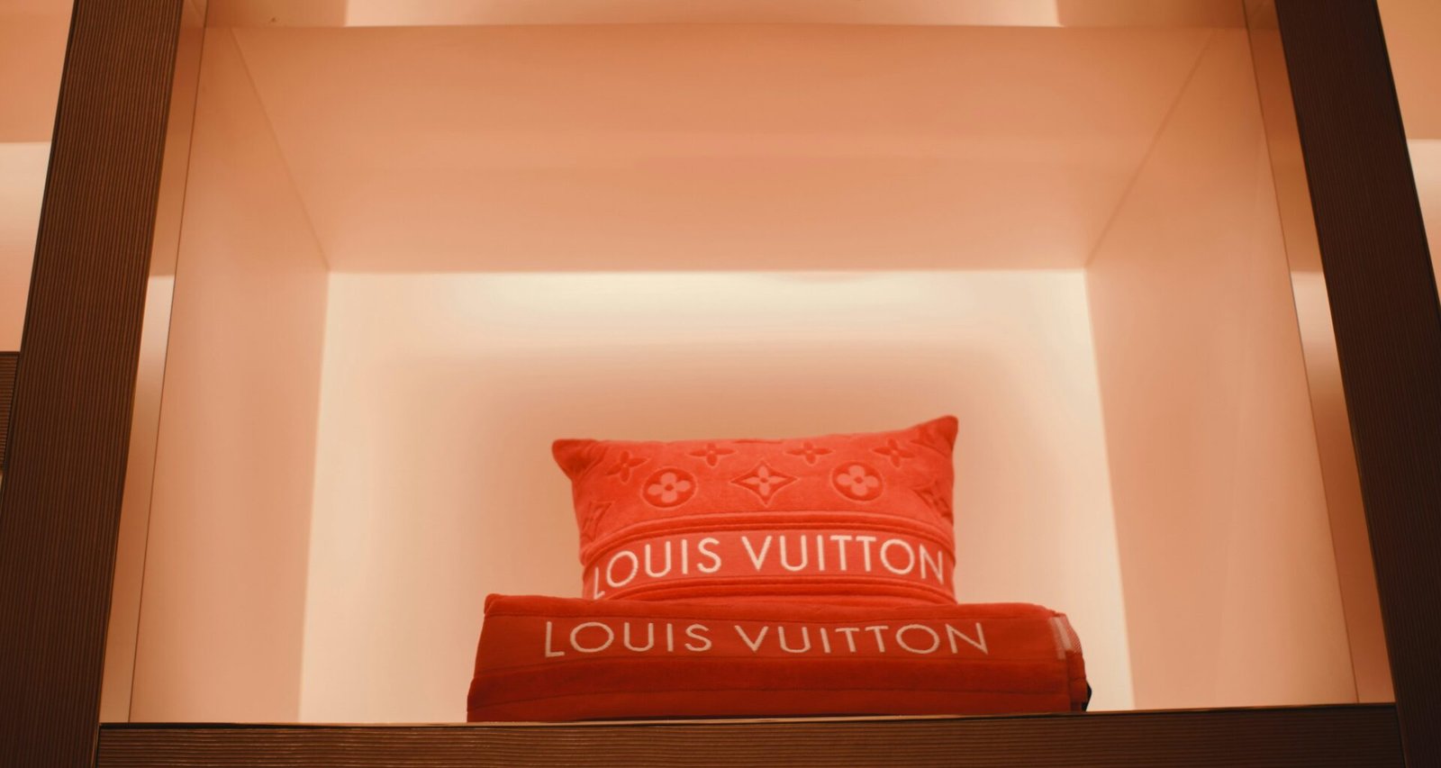 Rotes Kissen liegt oben auf einer hölzernen Leiter und dient als dekoratives Element in einem Raum