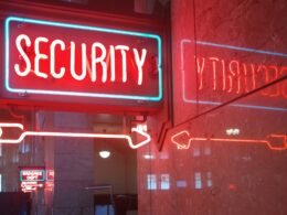 Zwei Sicherheitsschilder, eines rot und eines blau, symbolisieren verschiedene Sicherheitsaspekte im technologischen Umfeld.