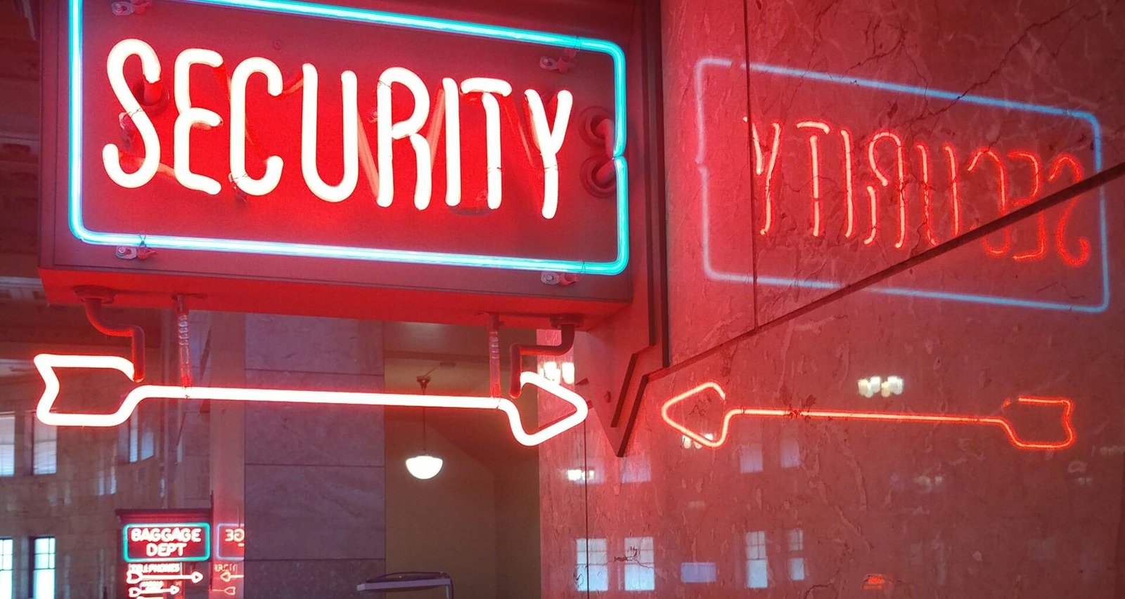 Rotes und blaues Sicherheitsschild nebeneinander, symbolisieren verschiedene Aspekte digitaler Sicherheit auf neutralem Hintergrund.