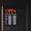 Tür mit einem Schild, das auf die aktuellen Öffnungszeiten eines Geschäfts hinweist, englischer Text: Open Business Hours