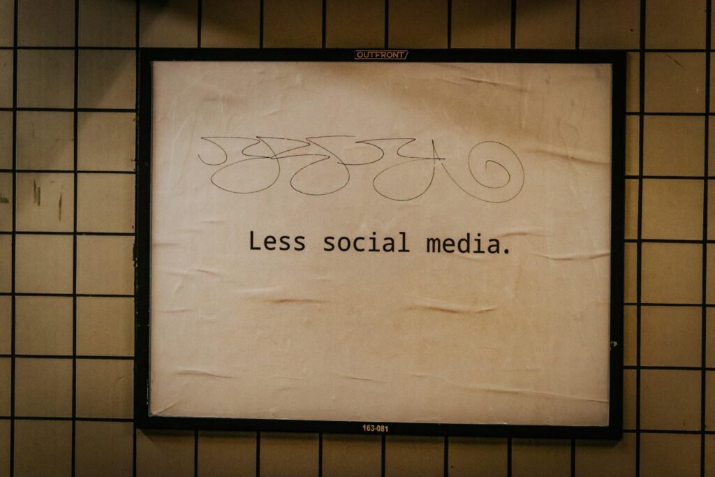 Schild an einer Wand mit dem Schriftzug 'less social media' als Hinweis für bewusste Social-Media-Nutzung