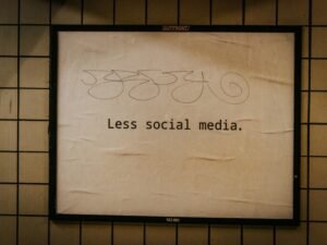 Schild an einer Wand mit dem Schriftzug 'less social media' als Hinweis für bewusste Social-Media-Nutzung