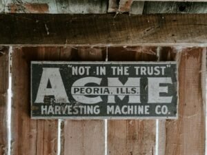 Ein rechteckiges Schild ist an einer Hauswand in einer modernen Stadt befestigt und steht im Blickpunkt der Fotografie.